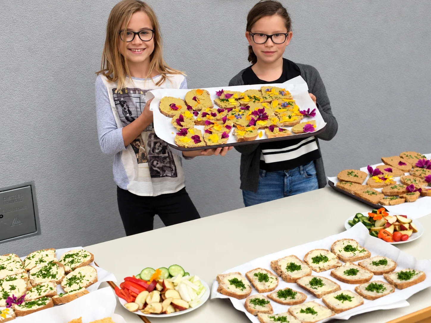 Schülerinnen der Fachschule St. Martin präsentieren Speisen mit Gemüse und Kräutern.