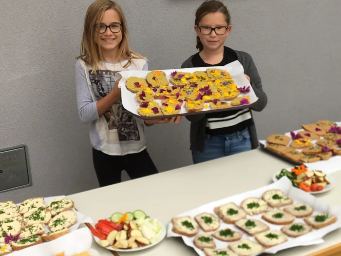 Schülerinnen der Fachschule St. Martin präsentieren Speisen mit Gemüse und Kräutern.