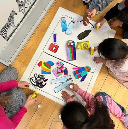 Kinder der Eulenschule gestalten gemeinsam Bilder und Gegenstände für ihren Klassenkoffer.