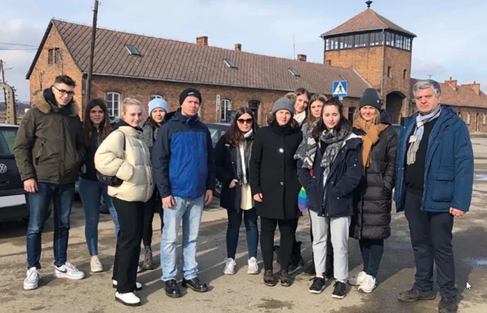 Teilnehmende des gemeinsamen Erinnerungsprojekts vor der Gedenkstätte Auschwitz.