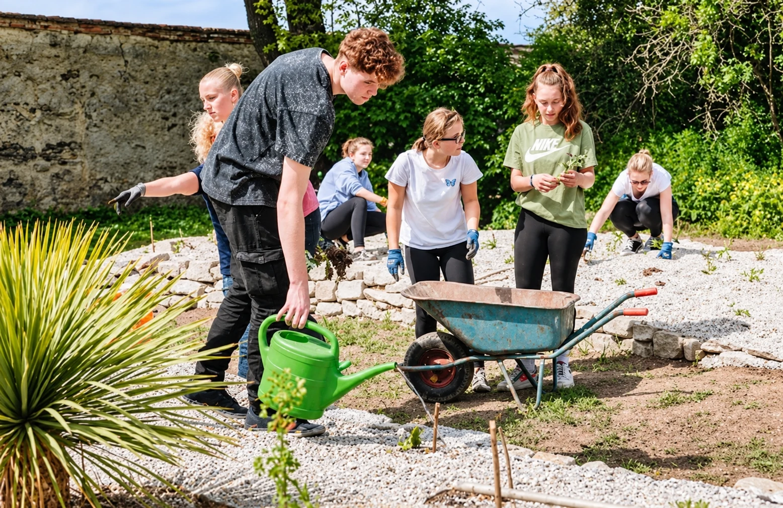 Schülerinnen und Schüler arbeiten gemeinsam mit Gartengeräten im Zukunftsgarten der HAK und HAS Wiener Neustadt.